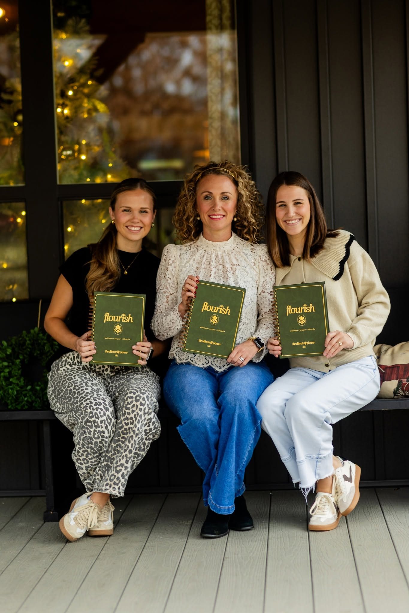 Three women holding copies of the Flourish planner